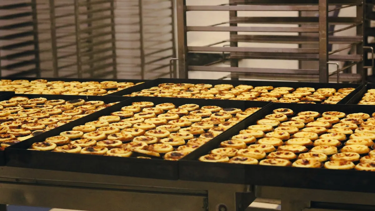 Bleche mit frisch gebackenem Gebäck in einer Großbäckerei